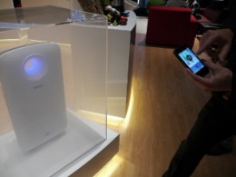 部屋に見立てた透明ケースの中にケムリを充満させ、スマホで空気清浄機能を作動させるようす